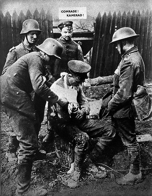 An old photo of four soldiers stood around an injured soldier in the foreground. A caption reads "COMRADE! KAMERAD!"